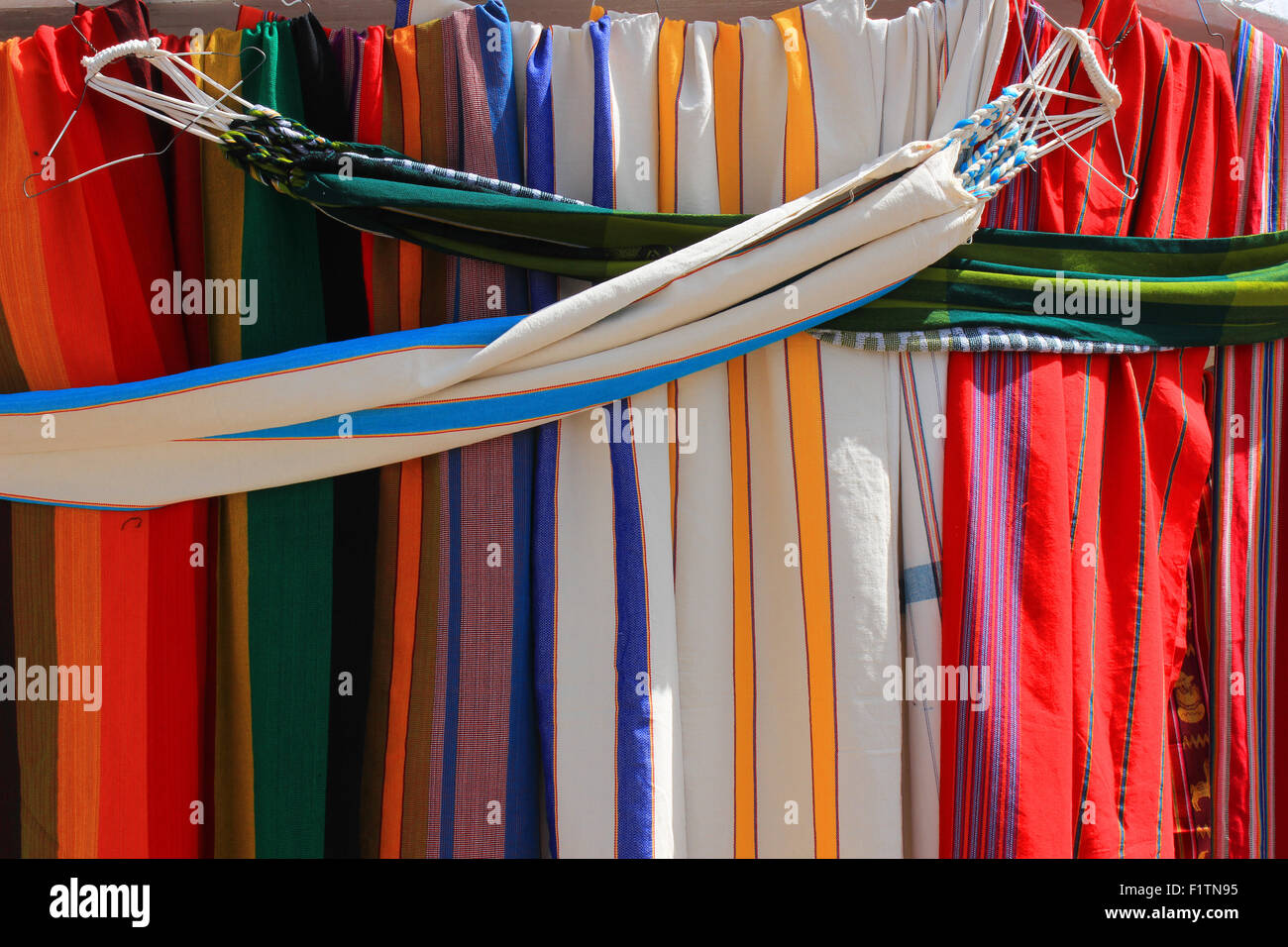Handmade hammocks in a variety of patterns and colors for sale at the outdoor craft market in Otavalo, Ecuador Stock Photo