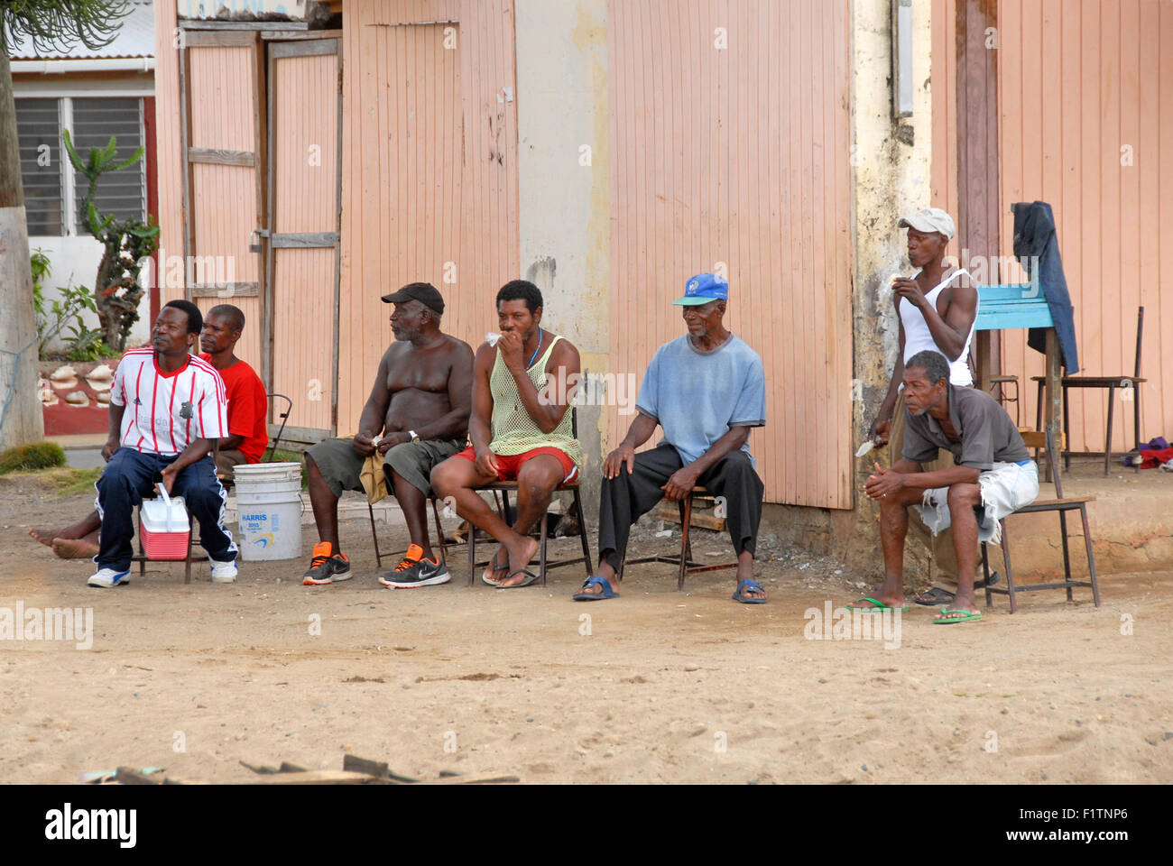 Unemployed men sitting on beach, St Lucia, Caribbean Stock Photo