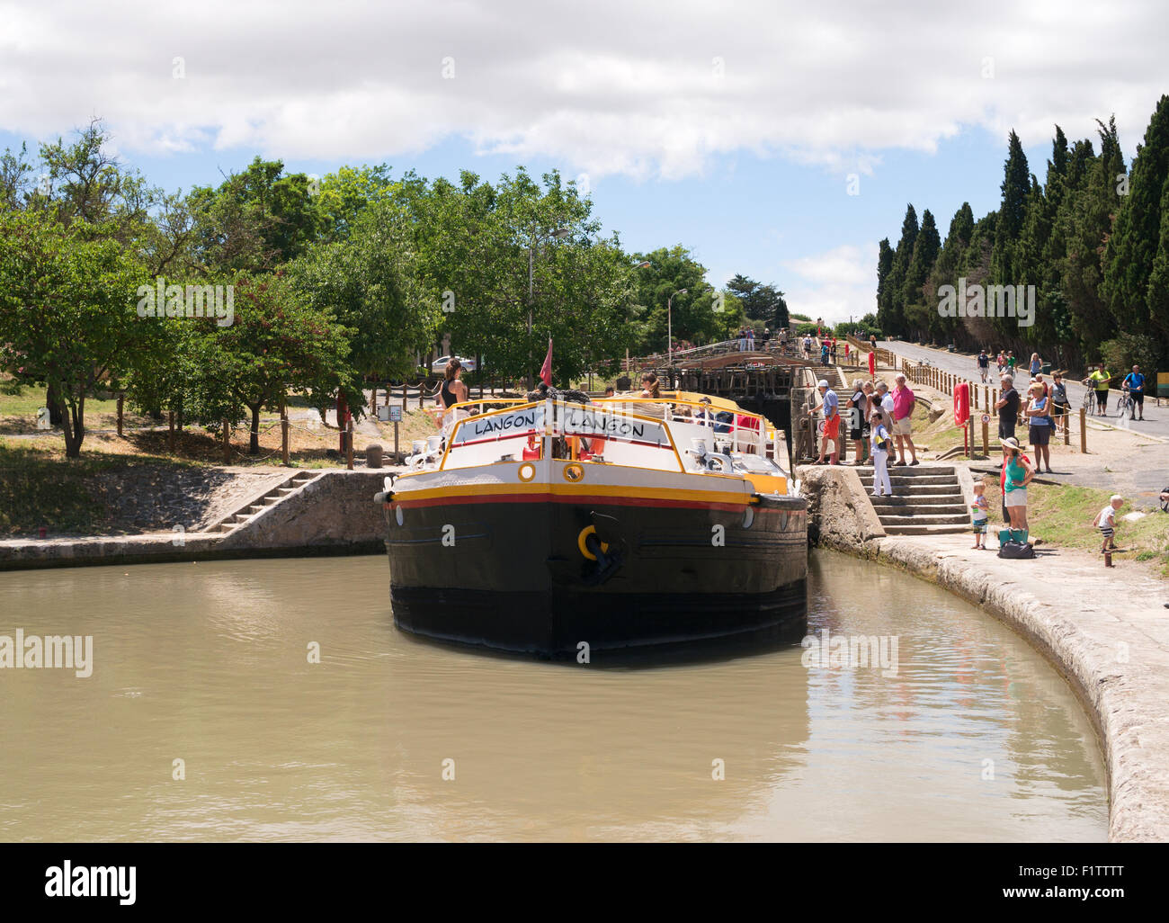 The large houseboat Langon leaving the Fonserannes locks at Béziers, Languedoc-Roussillon, France, Europe Stock Photo