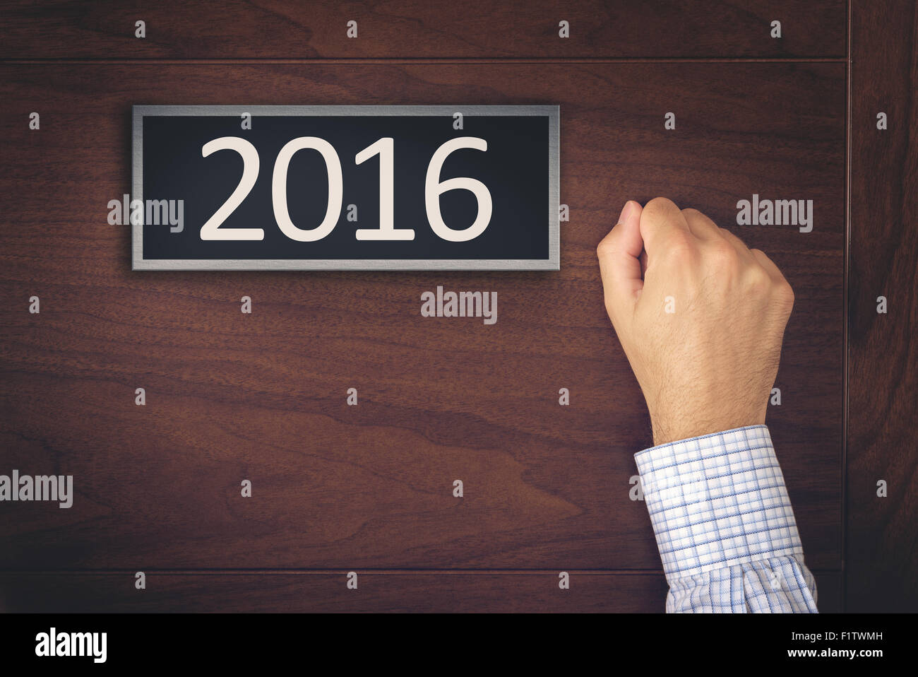 New Year 2016 Resolutions, Businessman Knocking on the Door with Number 2016. Stock Photo