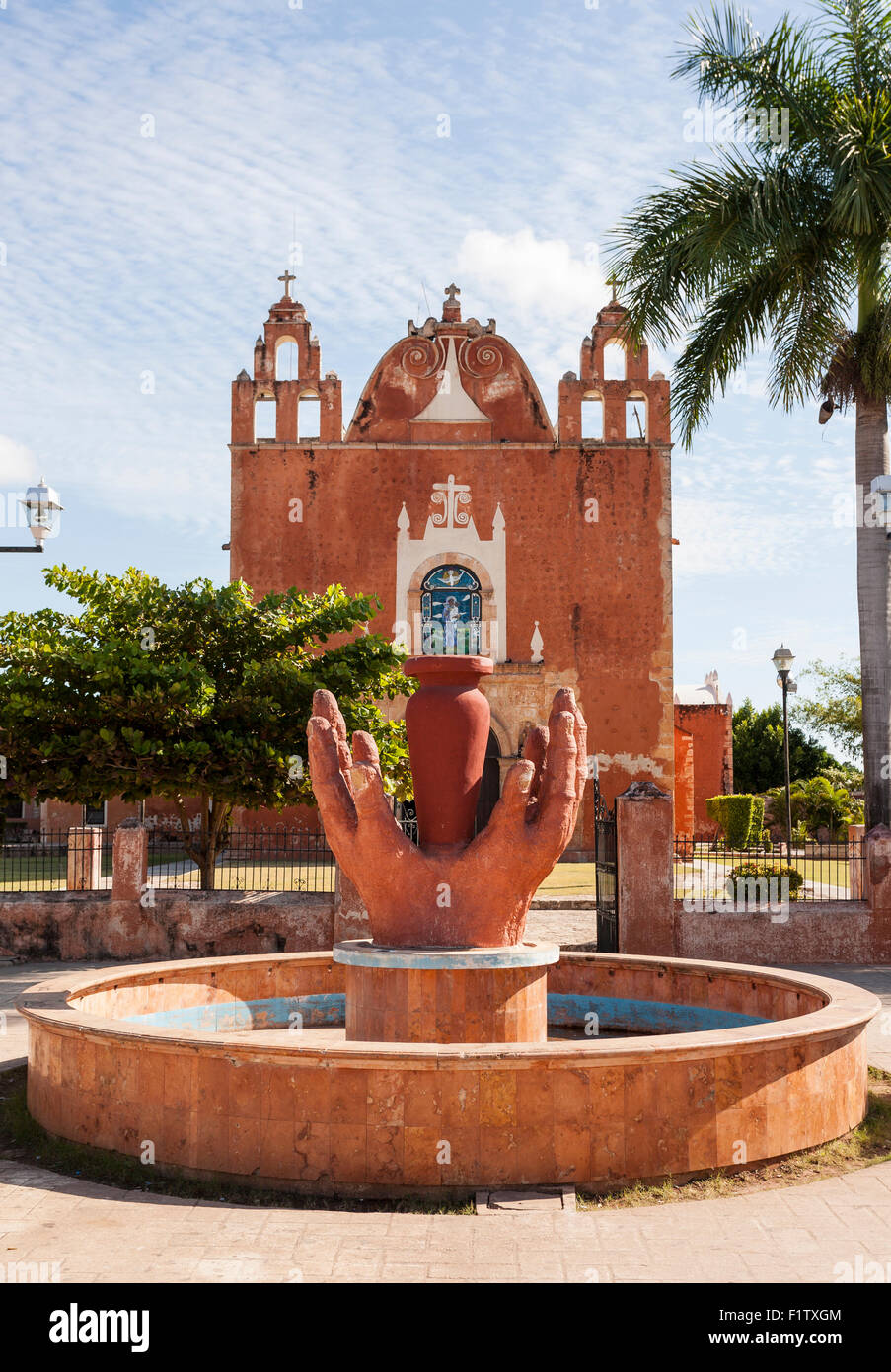 Hands of the potter in red clay frame the front facade of Ticul's church. The red hands echo the