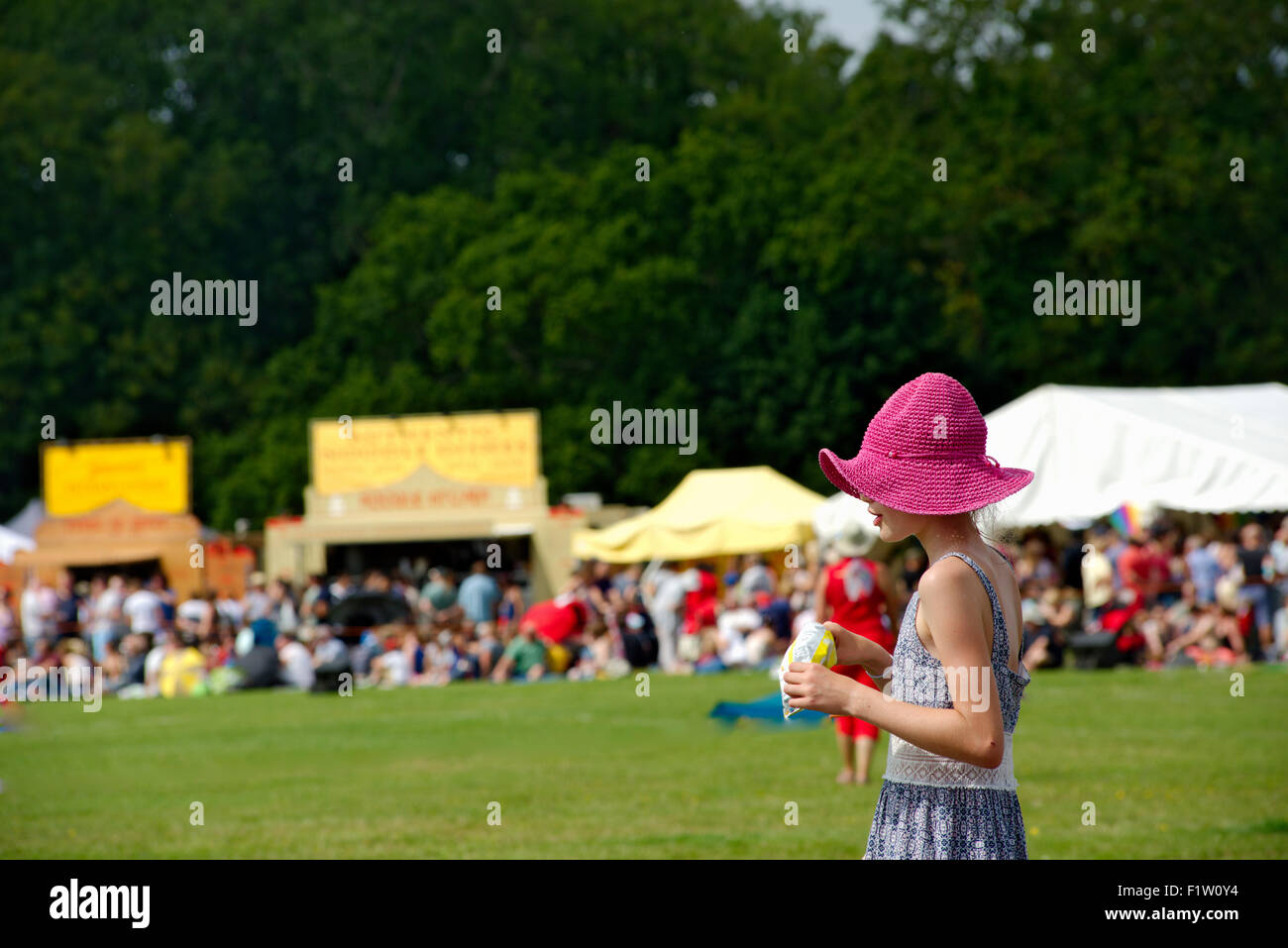 Young girl at festival with pink sun hat Stock Photo