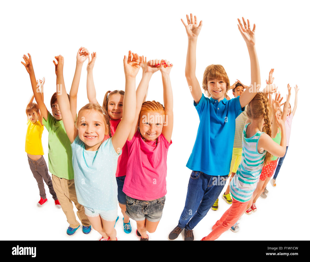 School age kids stand together with raised hands Stock Photo