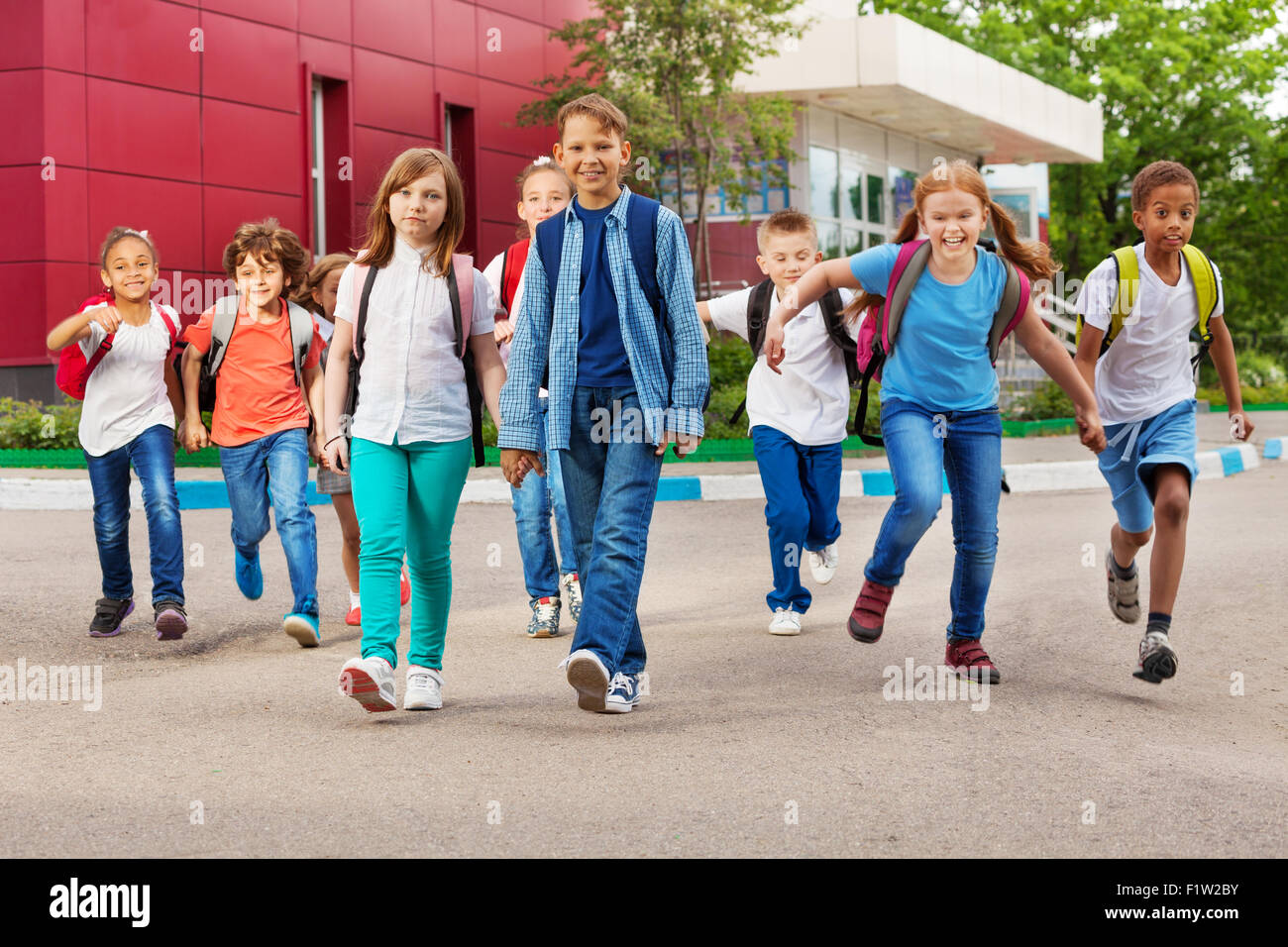 Children with rucksacks near school walking Stock Photo Alamy