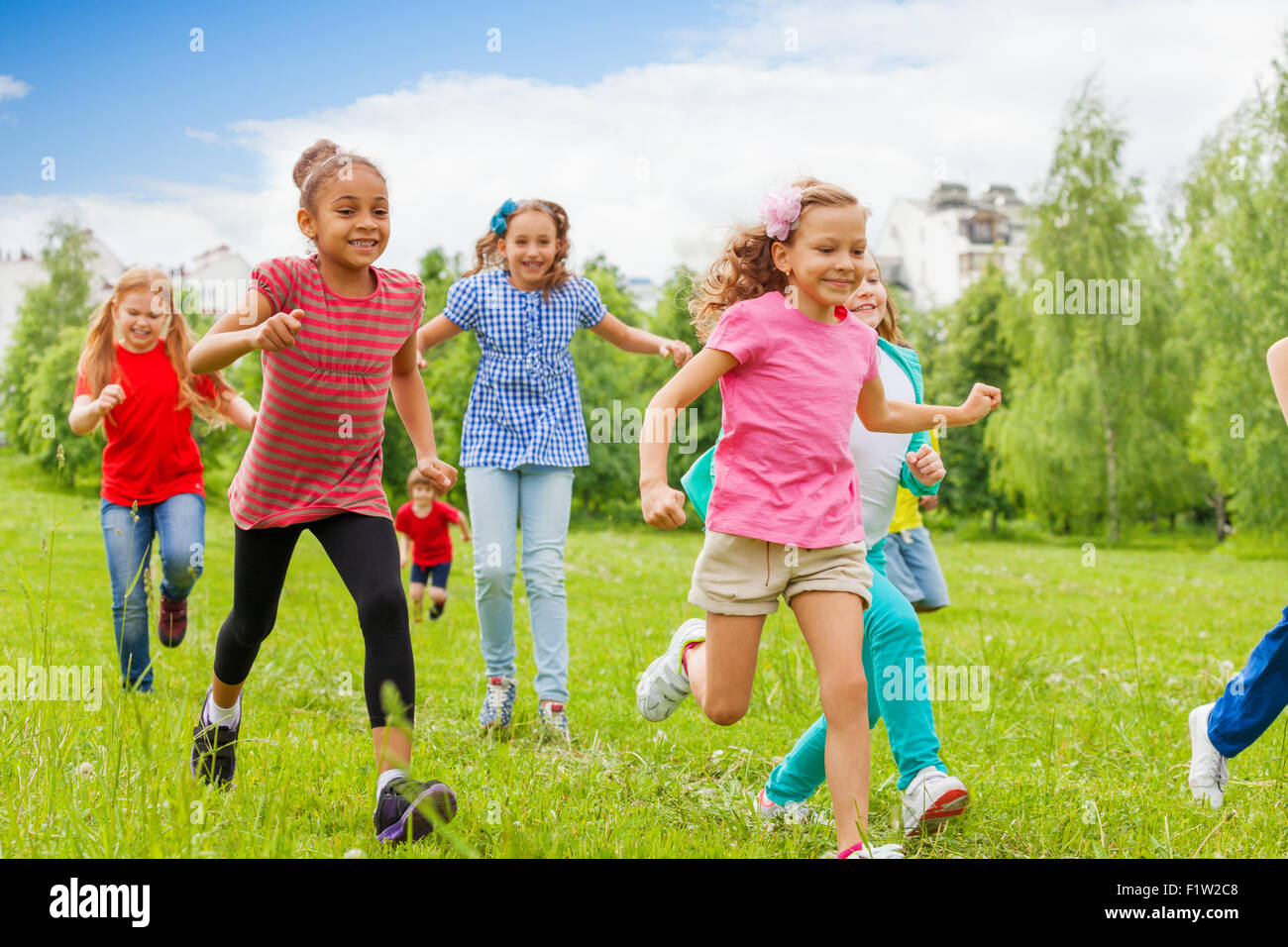 Group of happy kids running through green field Stock Photo Alamy