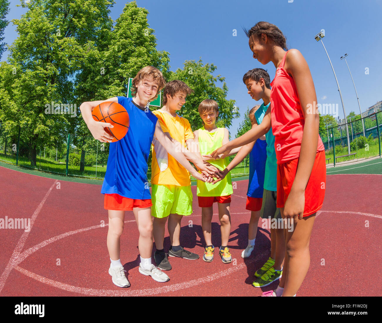 Teens before basketball hold arms in star shape Stock Photo