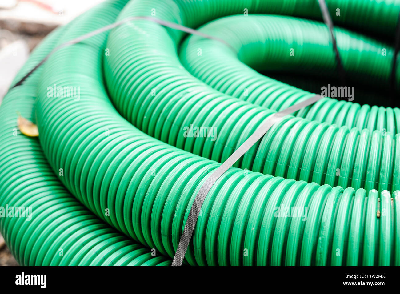 Roll of green tube of flexible plastic for the laying of optical fibers for telecommunications Stock Photo