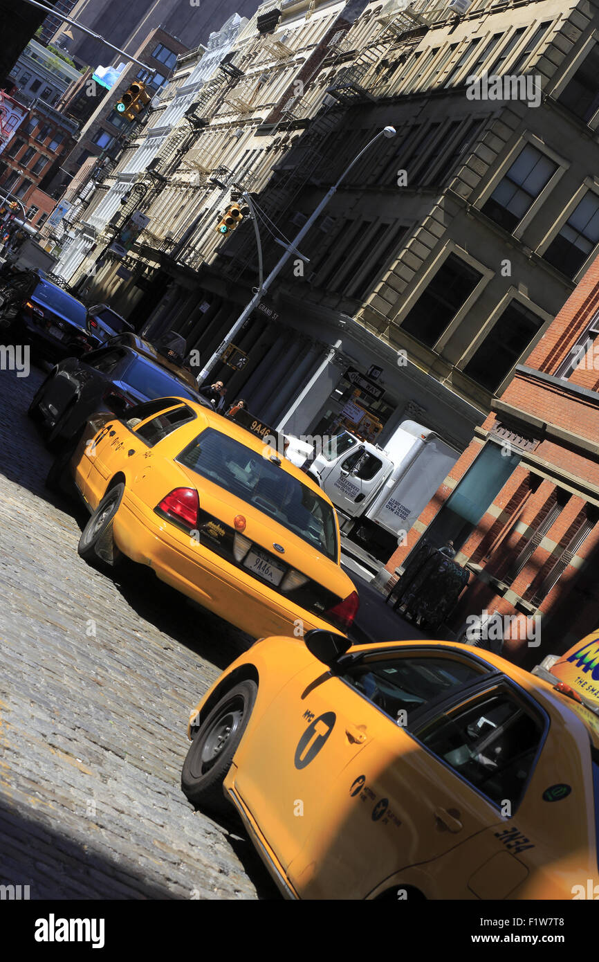 Yellow cab taxis on the street of Soho with cast-iron building in background. Lower Manhattan. New York City. USA Stock Photo