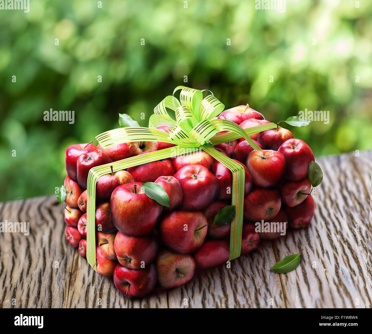 Apple gift box with green bow on the wooden table. Stock Photo
