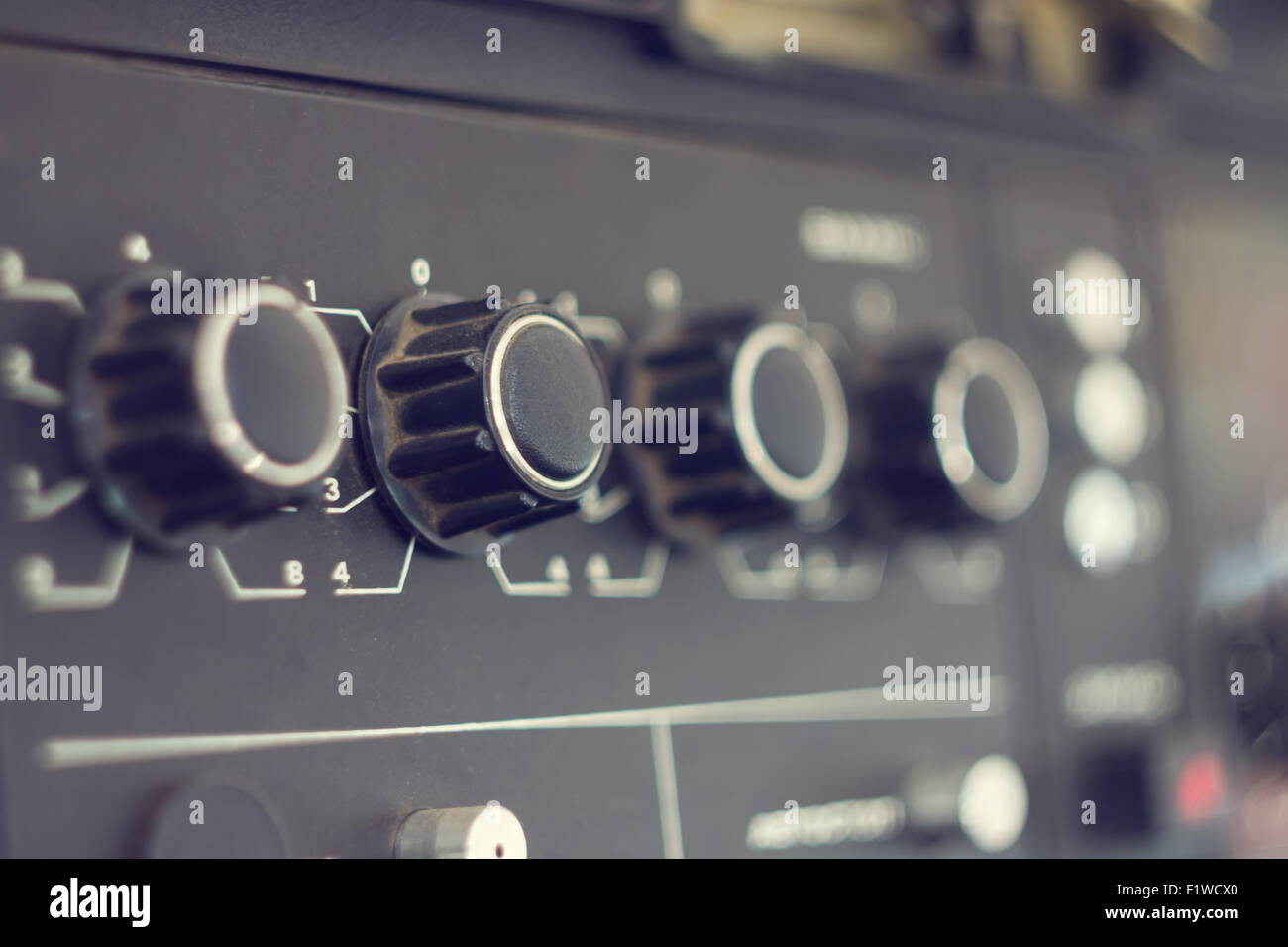 Piece of electrical audio equipment with knobs. Old retro amplifier with selective focus Stock