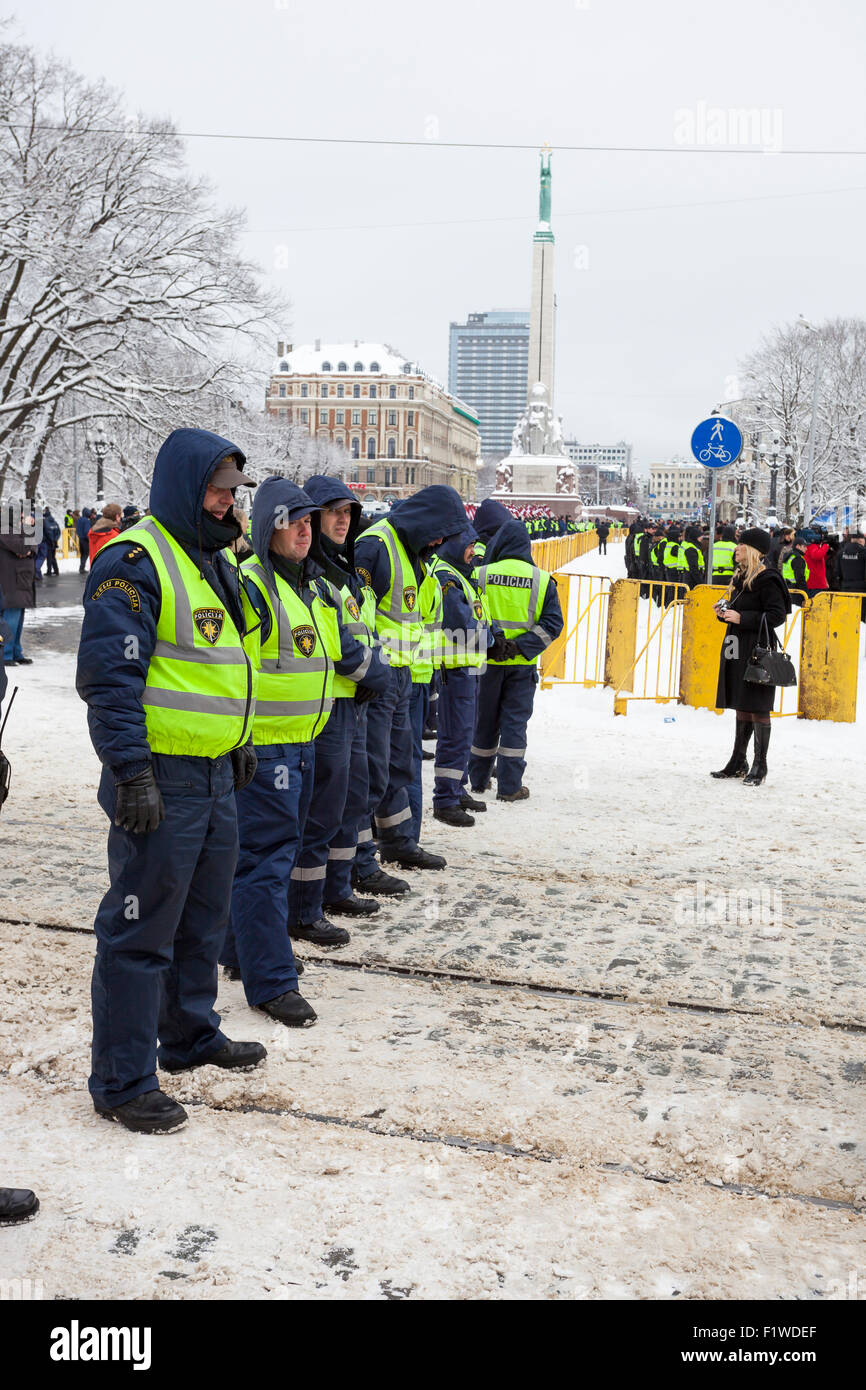 RIGA, LATVIA, MARCH 16, 2010: Local police guard cordon behind crowd control barriers at the Freedom Monument at the commemorati Stock Photo