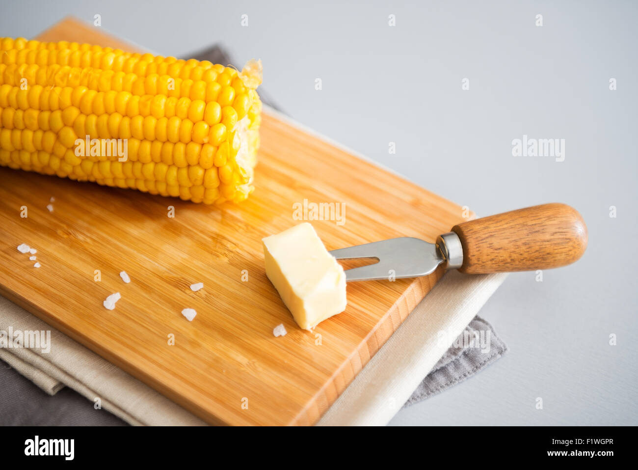 A hot corn on the cob, and a pat of cold butter waiting to be put on