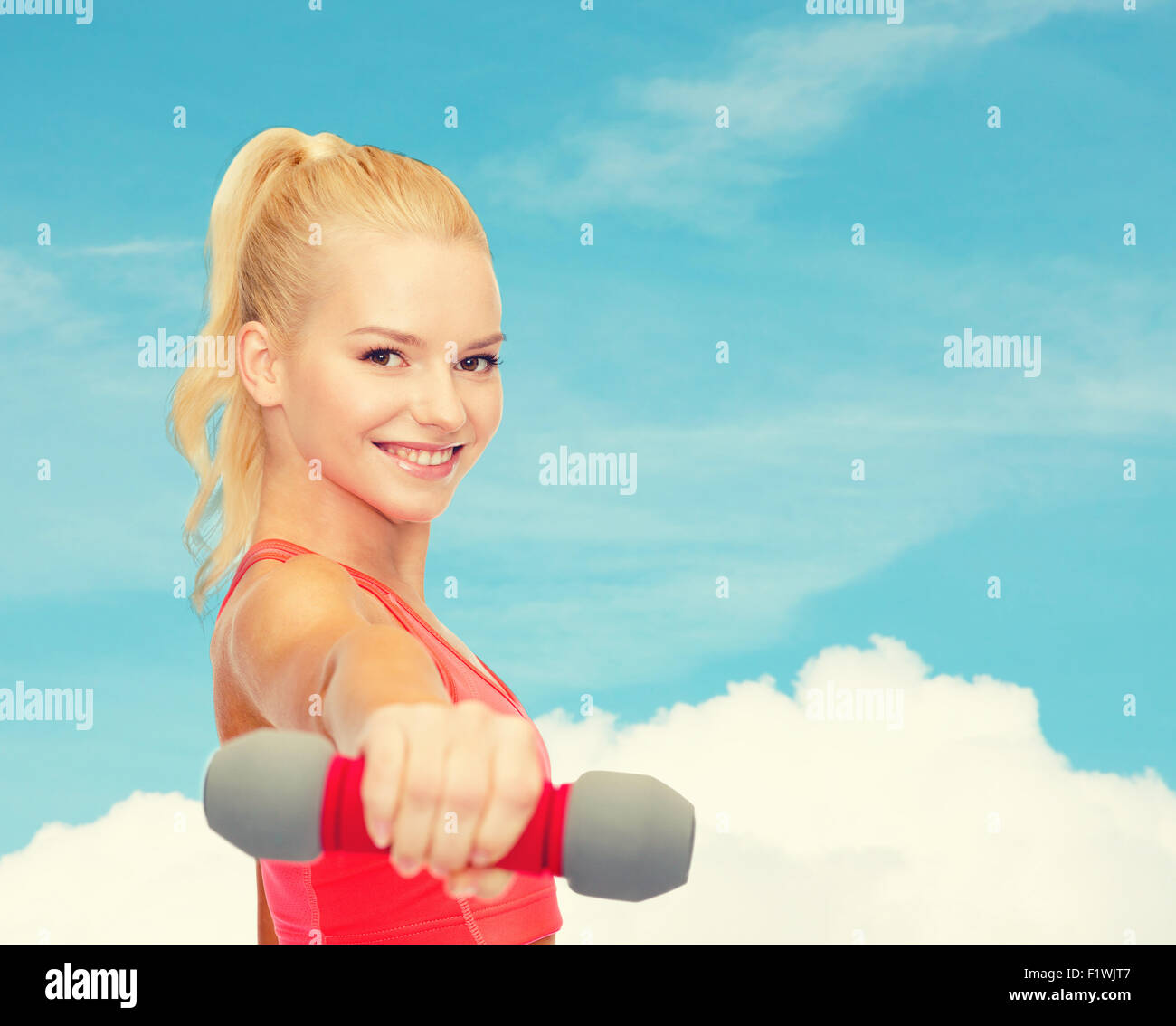 smiling beautiful sporty woman with dumbbell Stock Photo