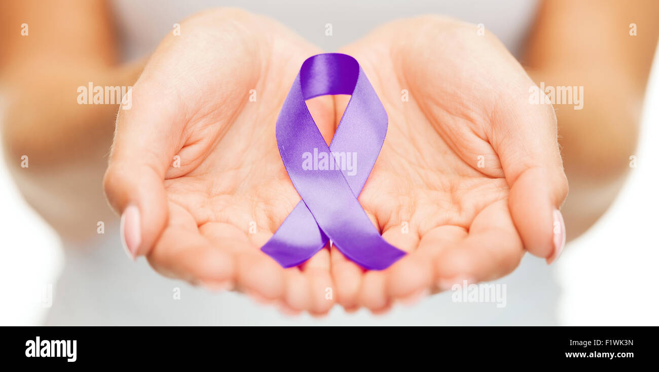 hands holding purple awareness ribbon Stock Photo