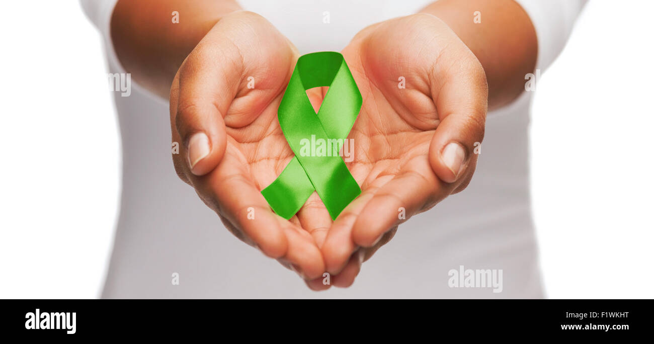 hands holding green awareness ribbon Stock Photo - Alamy