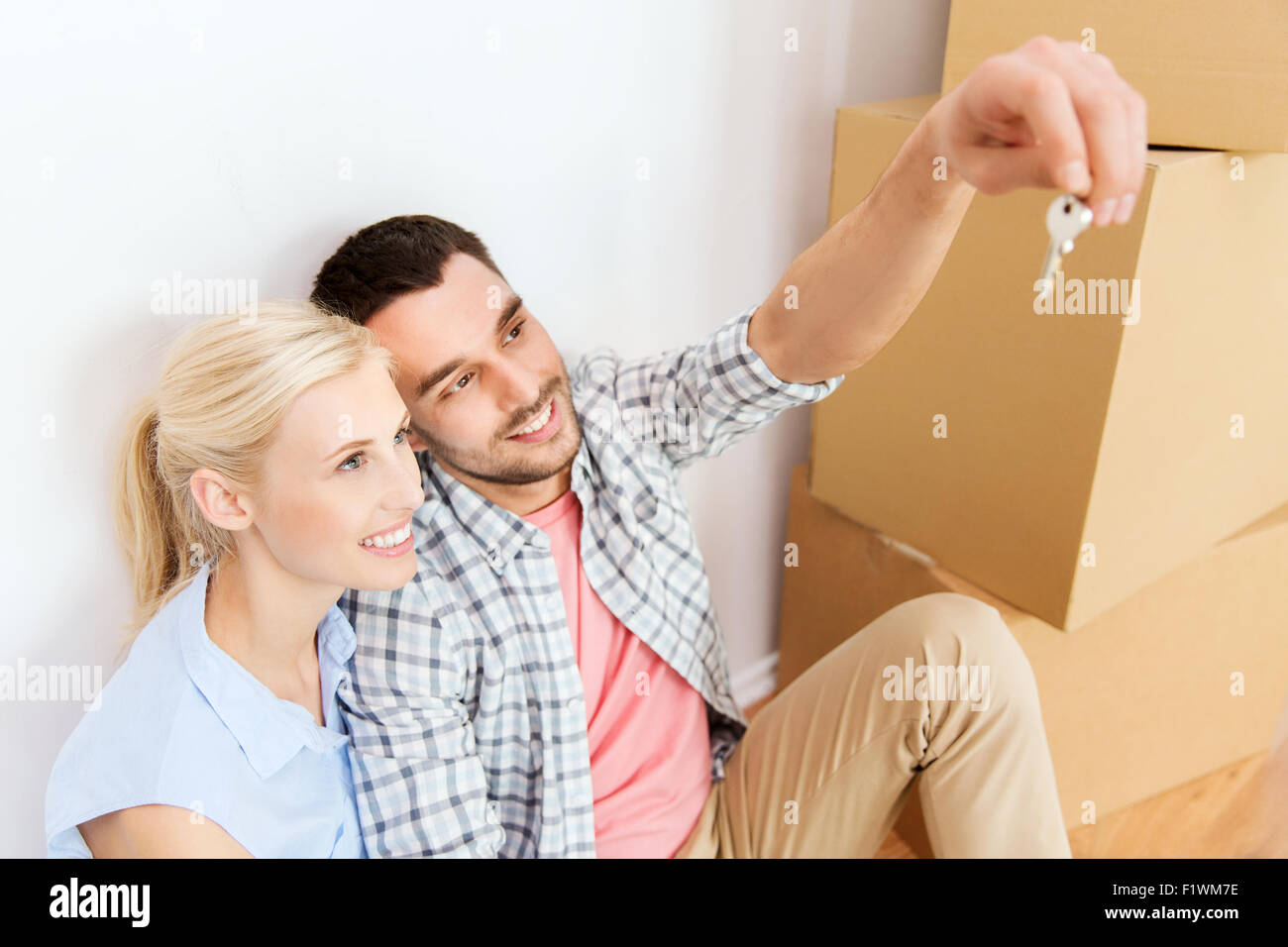 couple with key and boxes moving to new home Stock Photo - Alamy