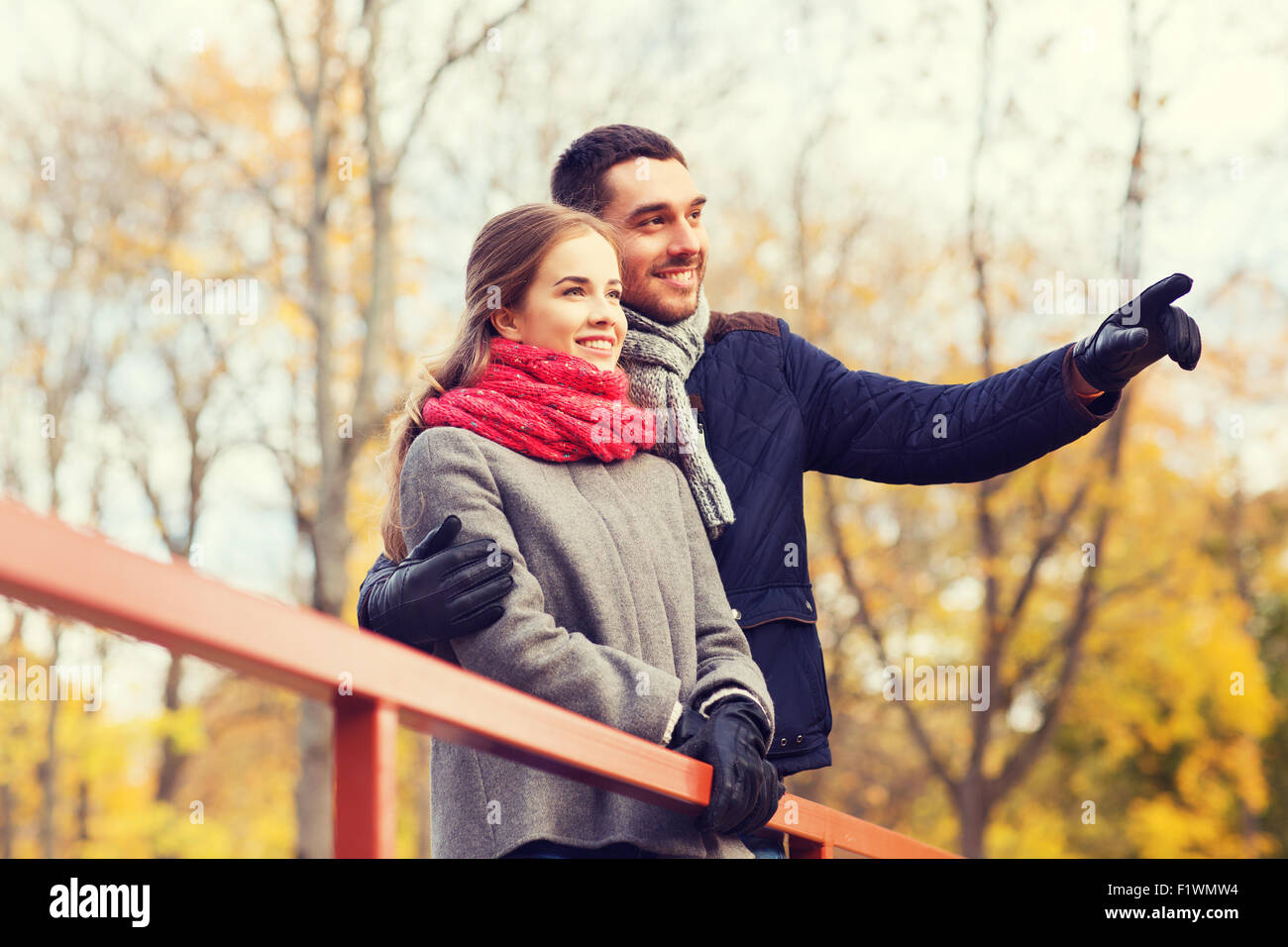 smiling couple hugging on bridge in autumn park Stock Photo - Alamy