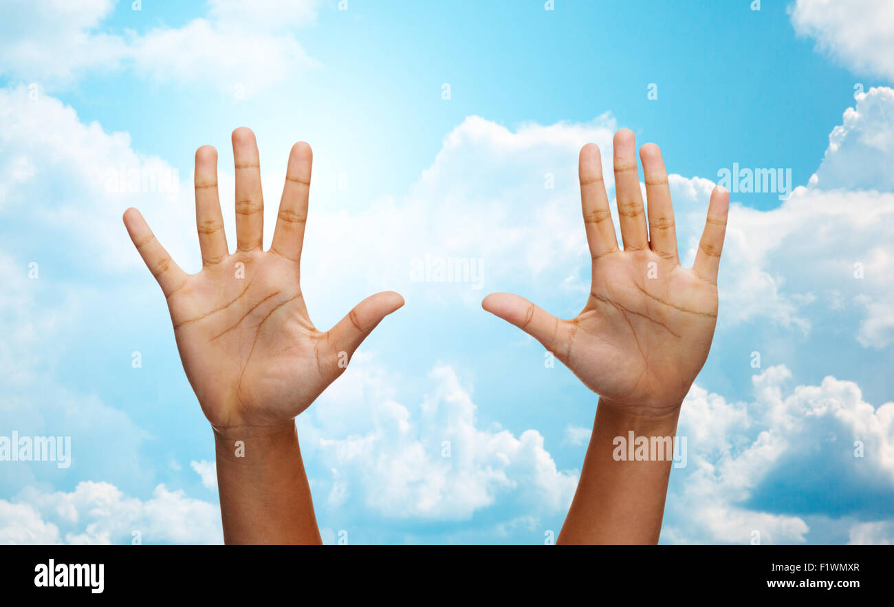 two african hands making high five over blue sky Stock Photo