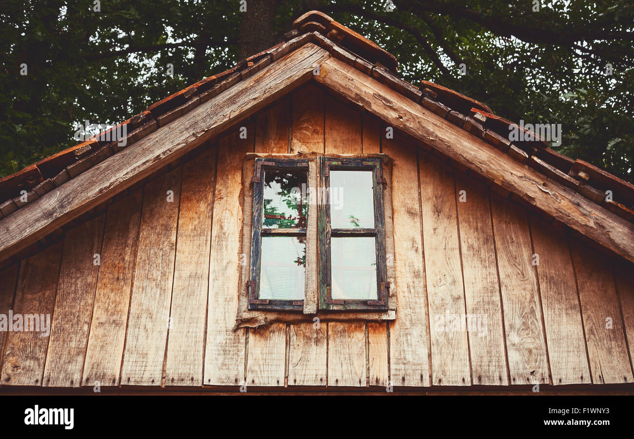 Details of an old wooden house, view on window and part of a roof. Stock Photo