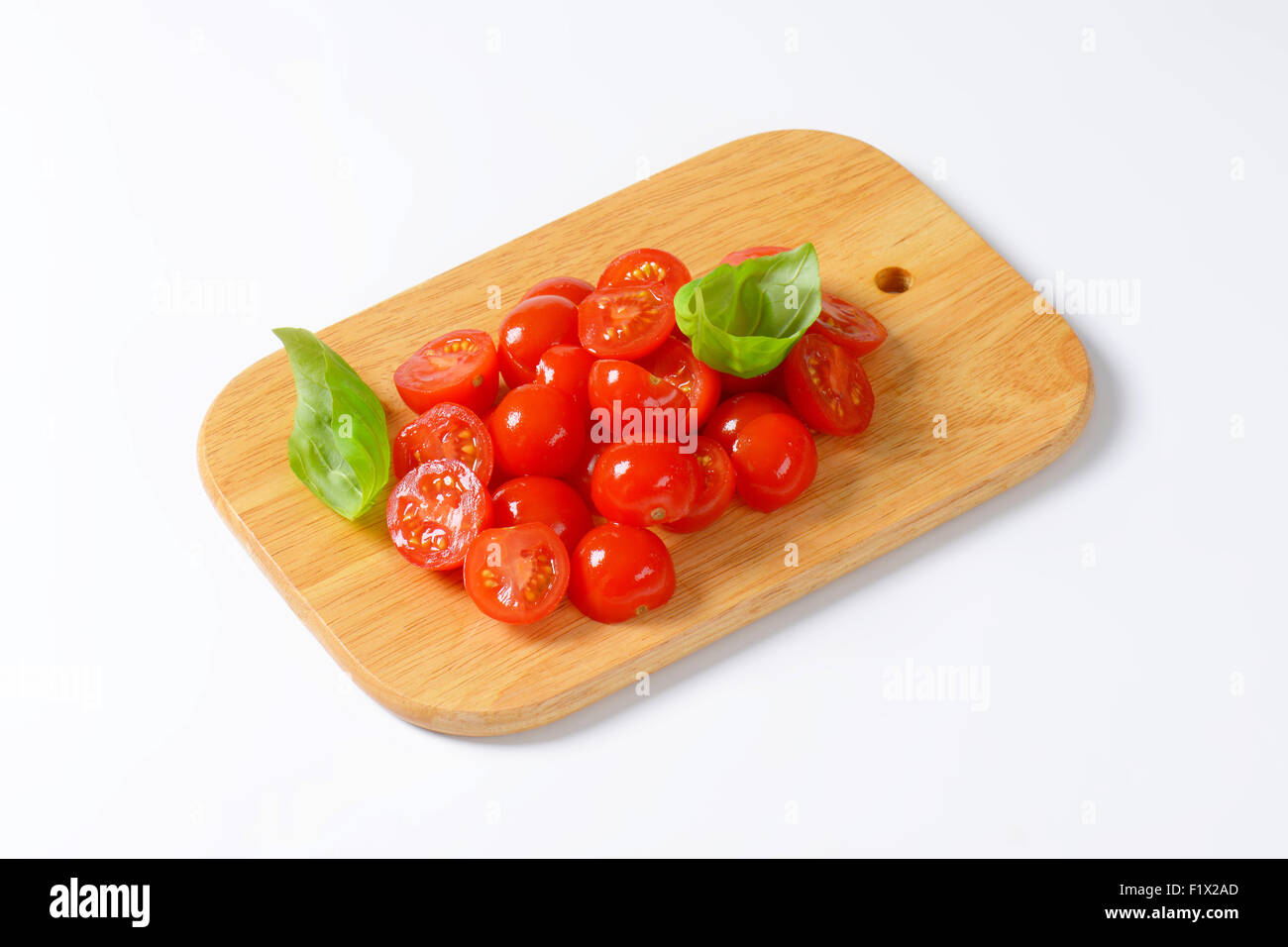 Halved cherry tomatoes on cutting board Stock Photo - Alamy