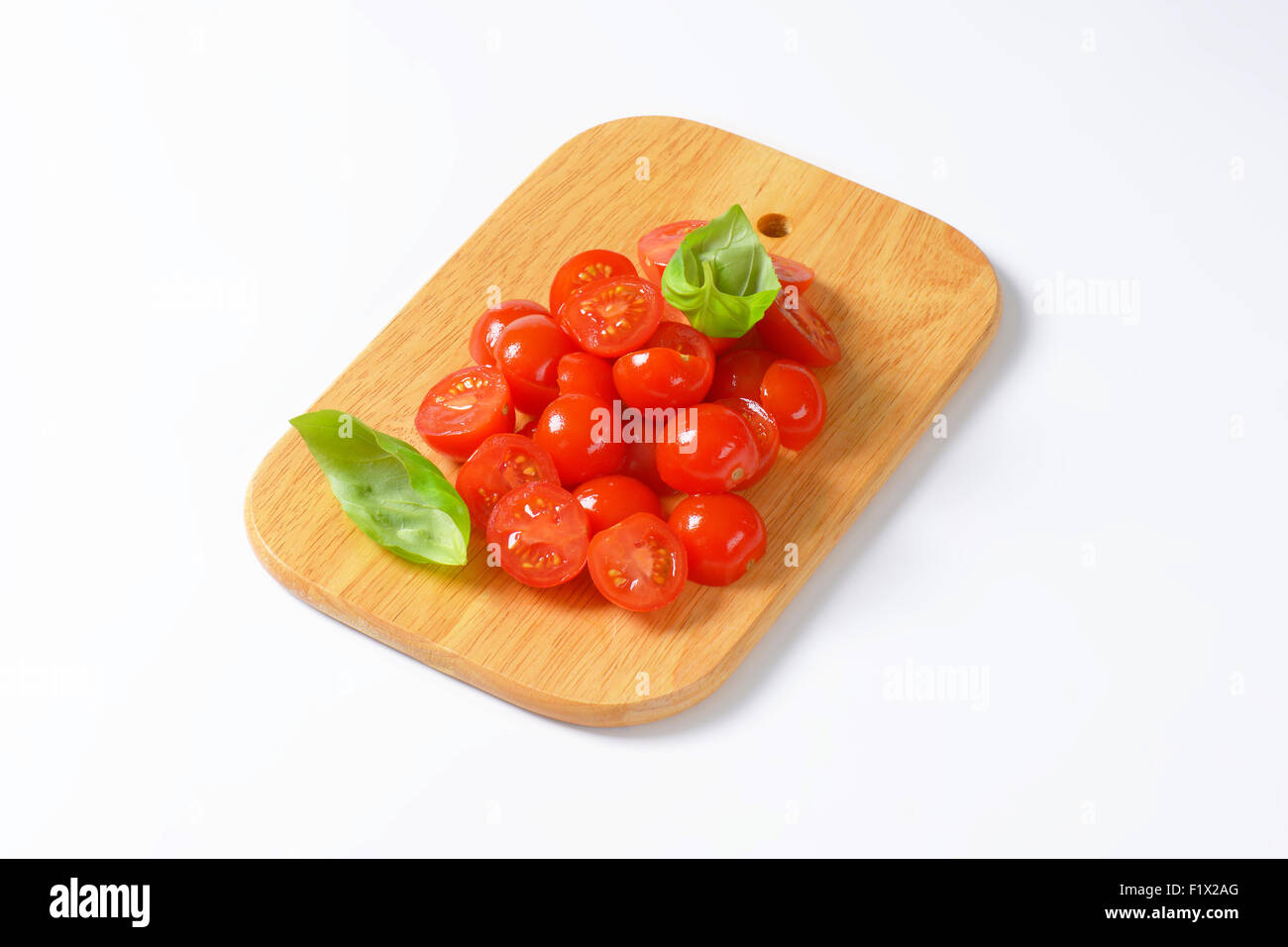 Halved cherry tomatoes on cutting board Stock Photo - Alamy