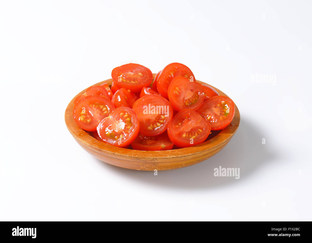 Halved cherry tomatoes in wooden bowl Stock Photo - Alamy
