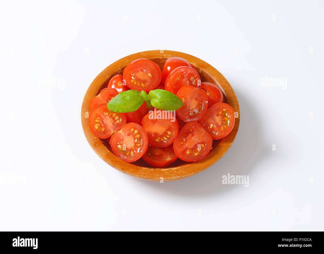 Halved cherry tomatoes in wooden bowl Stock Photo - Alamy