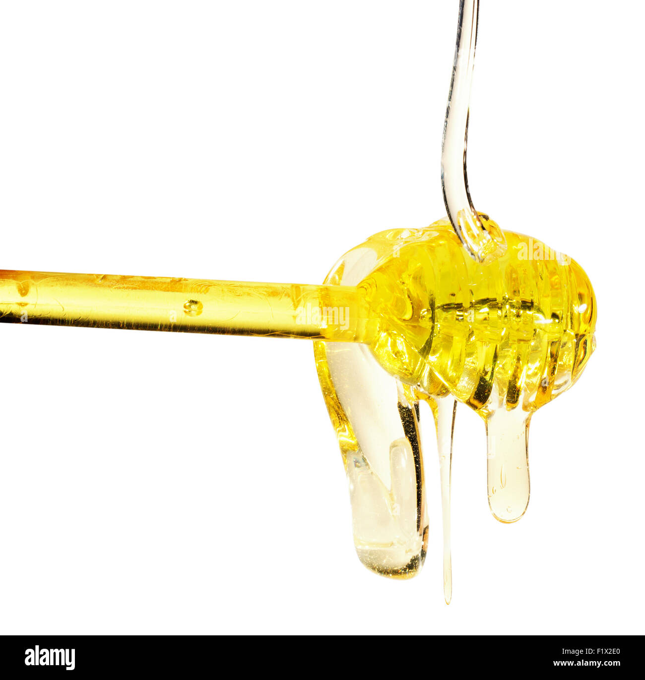 Honey dripping from a spoon on white background. Stock Photo