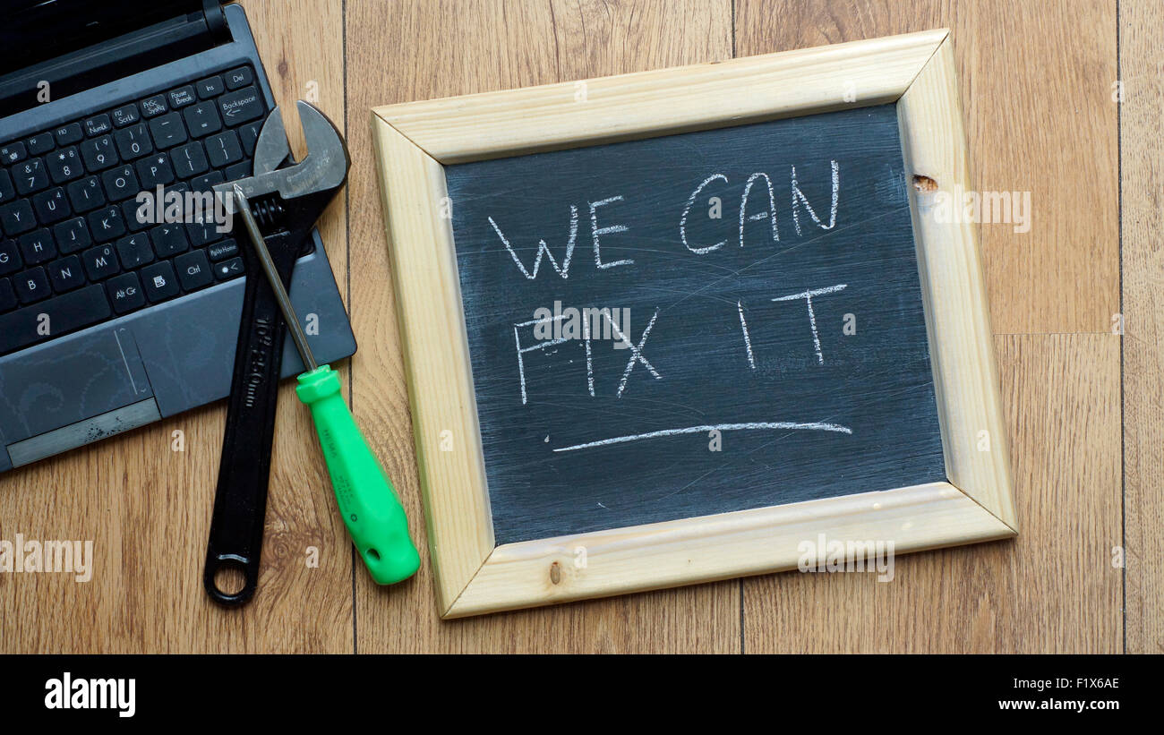 We can fix it written on a chalkboard next to a computer Stock Photo Alamy