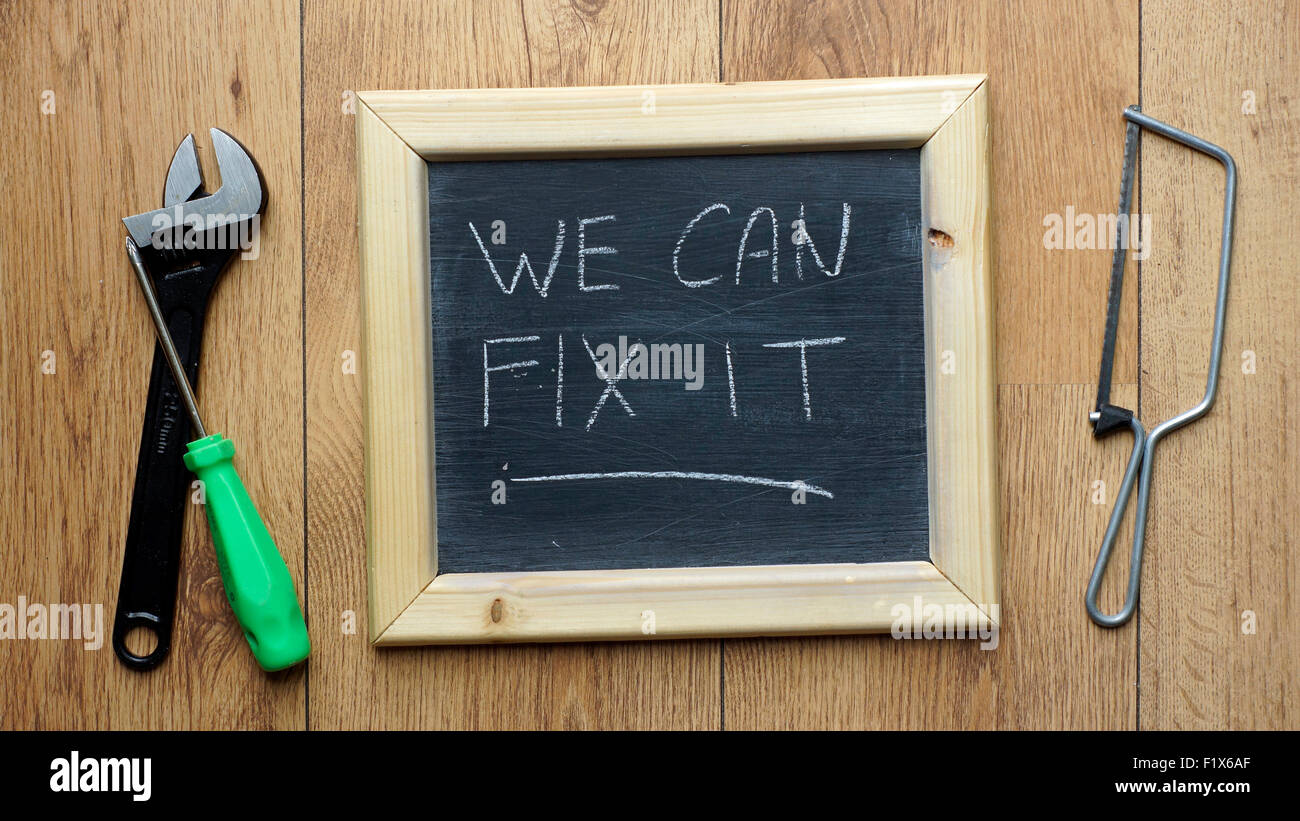 We can fix it written on a chalkboard next to worktools Stock Photo Alamy