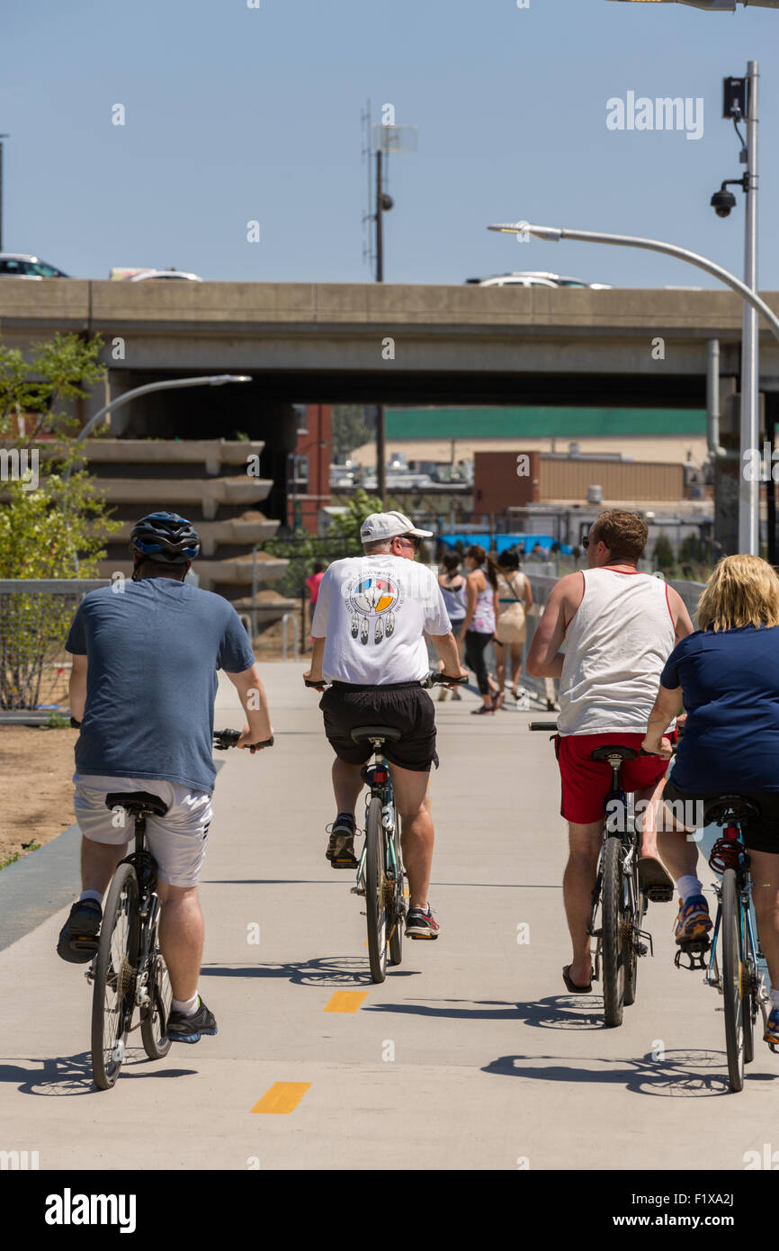 Bicyclists ride along the 606 elevated bike trail, green space and park