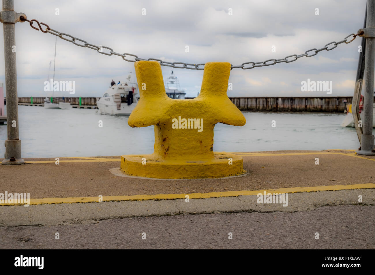 Yellow mooring post in a harbour Stock Photo