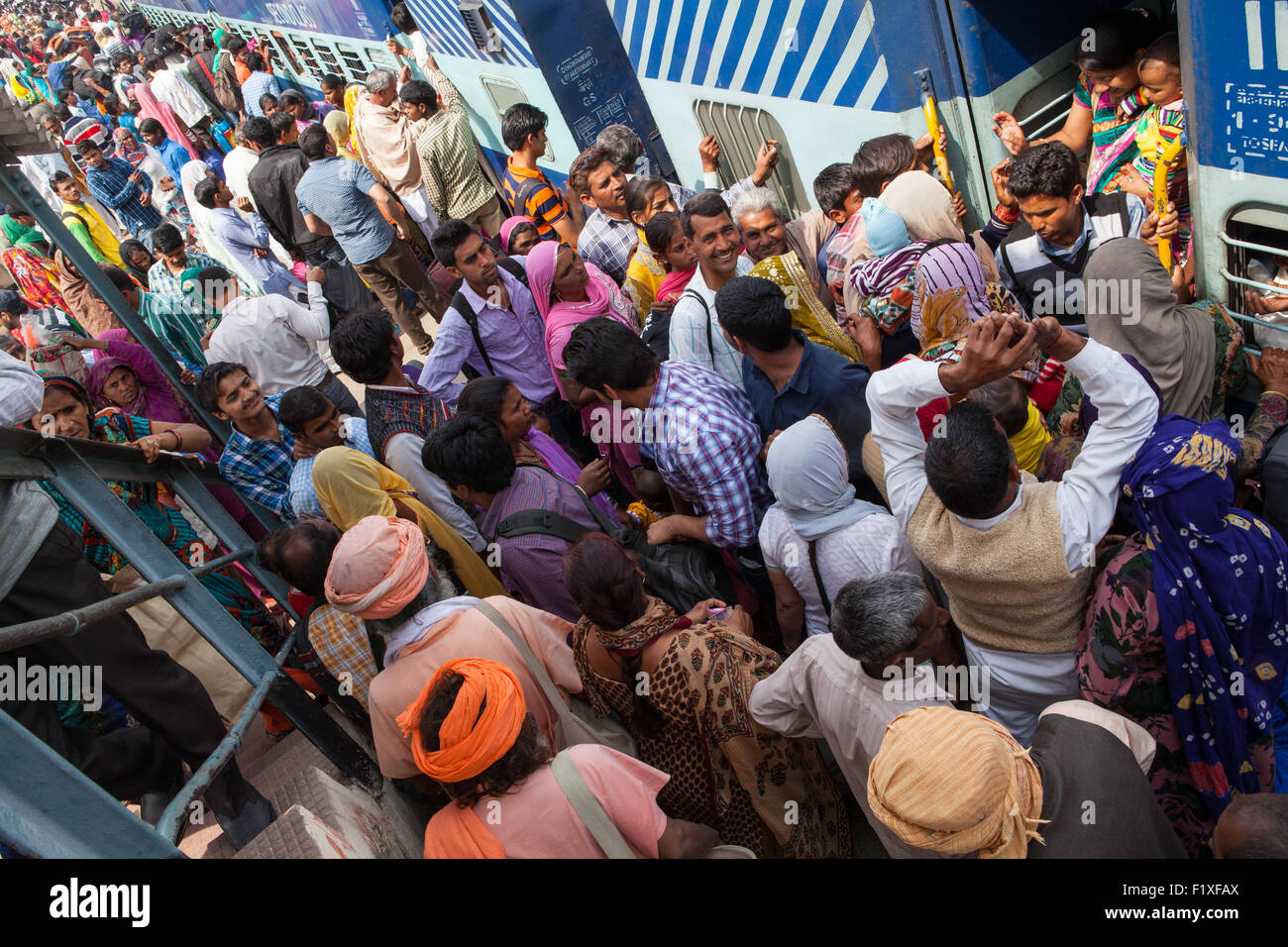 A crowd of passengers scramble to board a stationary train at the Railway Station in Rohtak Stock Photo