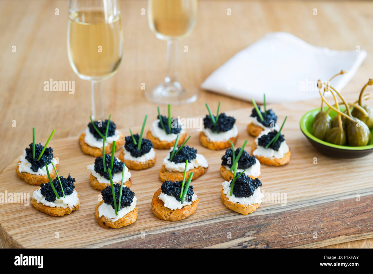 Canapes made from crostini with soft cheese and seaweed 'caviar'. Stock Photo