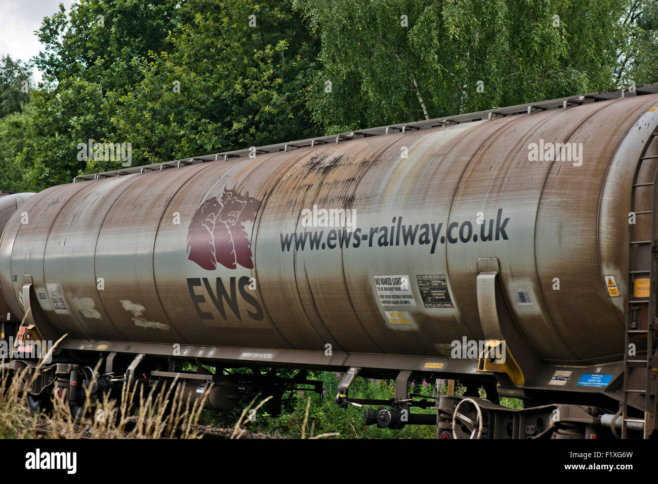 EWS tankers/cargo containers on railway line next to the Whisby Nature Park, Near Lincoln, Lincolnshire, UK Stock Photo