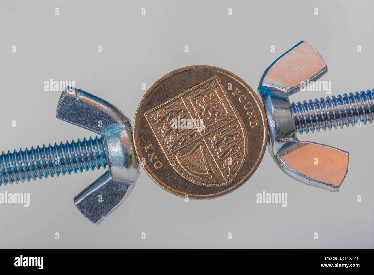 Turn the screw concept, pressurize. Macro of old style UK £1 coin