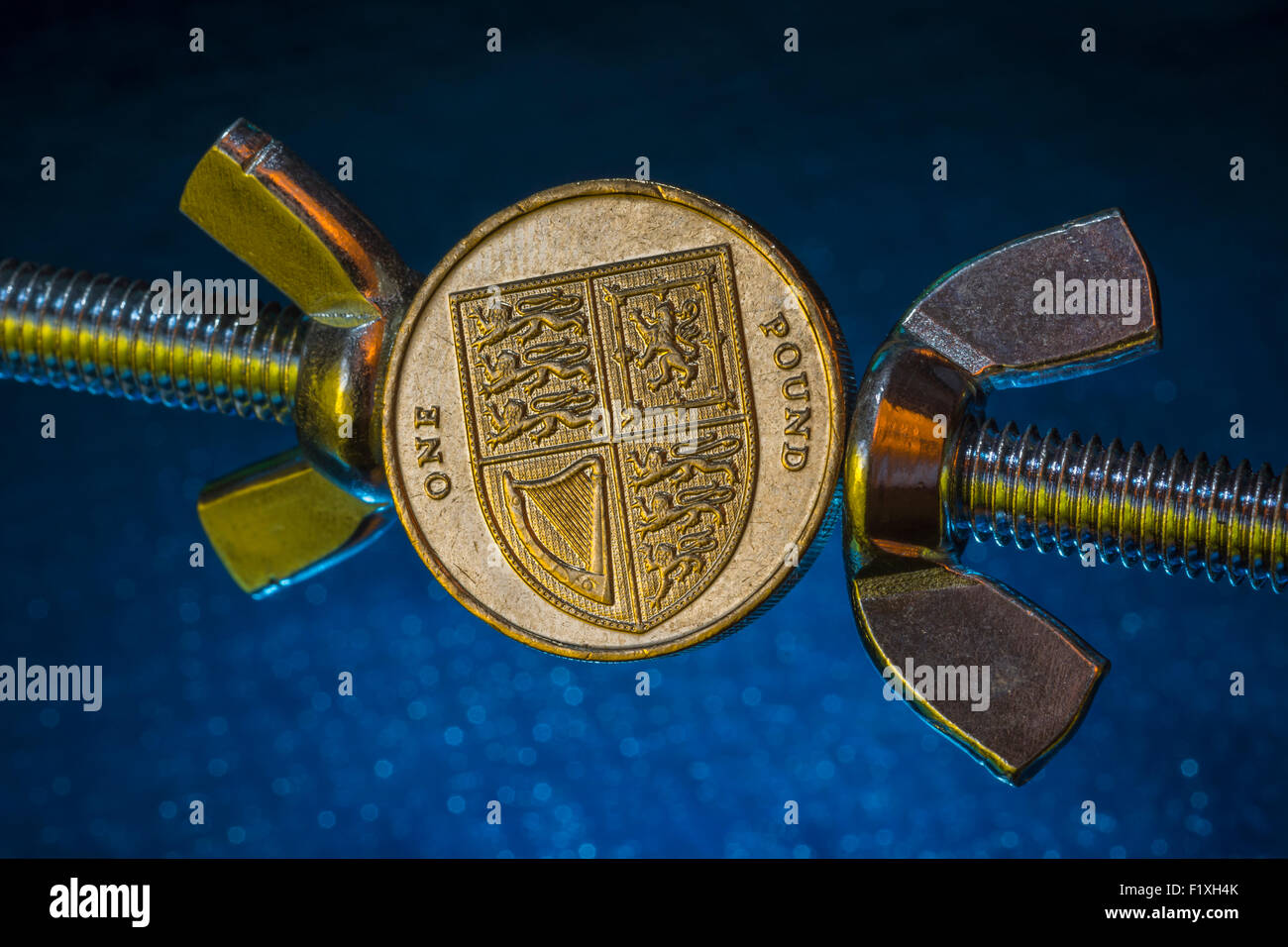 Turn the screw concept, pressurize. Macro of old style UK £1 coin