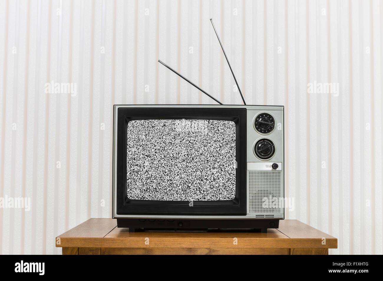 Old analogue television on wood table with static screen. Stock Photo