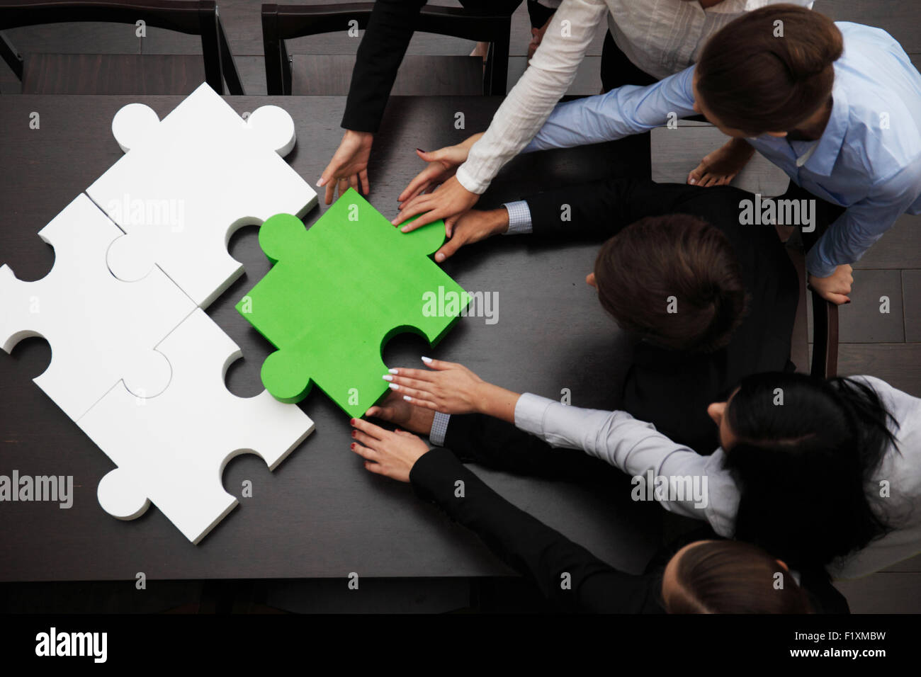 business team solving puzzle Stock Photo