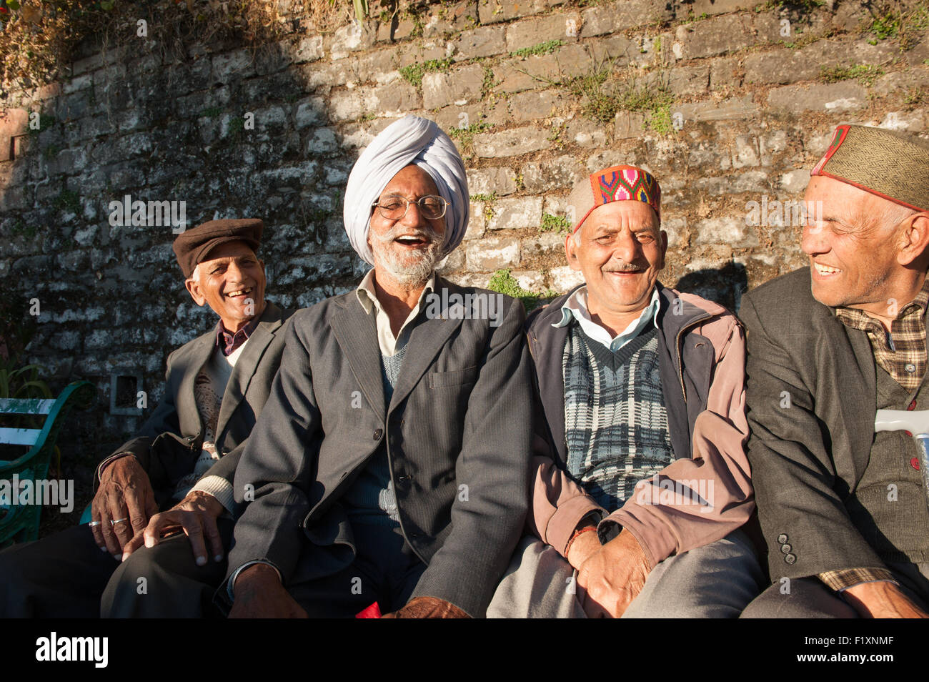 Shimla, Himachal Pradesh, India. Group of pensioners sitting on a bench, laughing. Stock Photo