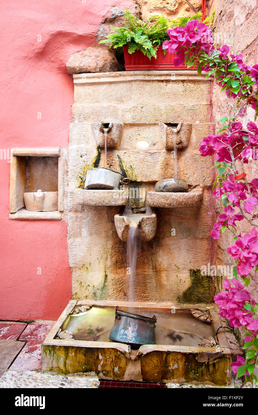 Portrait image of a water featutre set within the courtyard of the Veneto Restaurant in Rethymnon on the island of Crete. Stock Photo