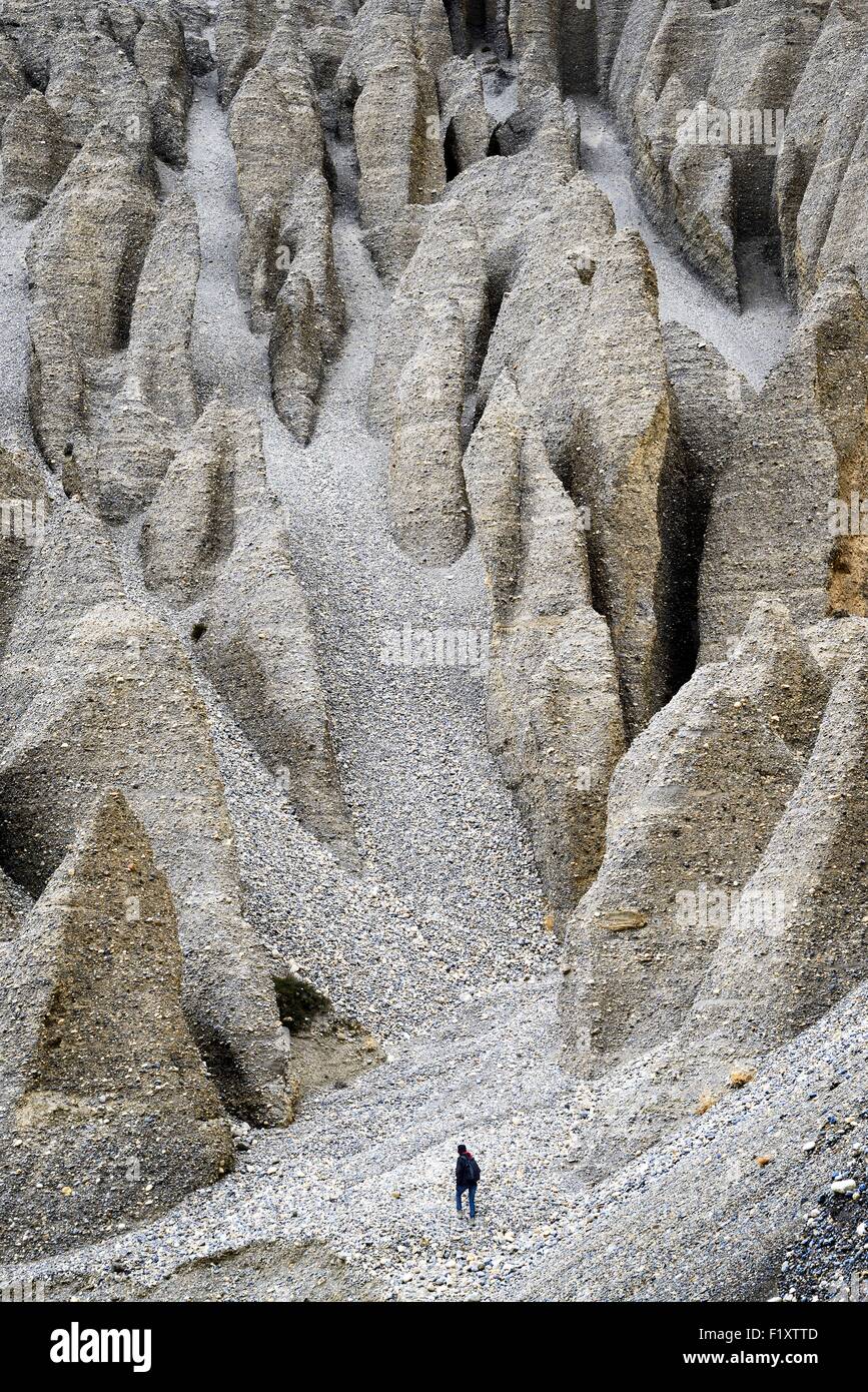 Nepal, Gandaki zone, Upper Mustang (near the border with Tibet), trekker among rock formations with strange shapes between Tangbe and Chuksang villages Stock Photo