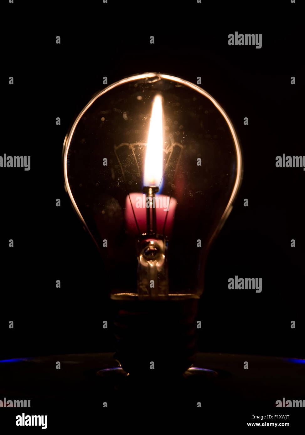 Lightbulb and candle flame Stock Photo