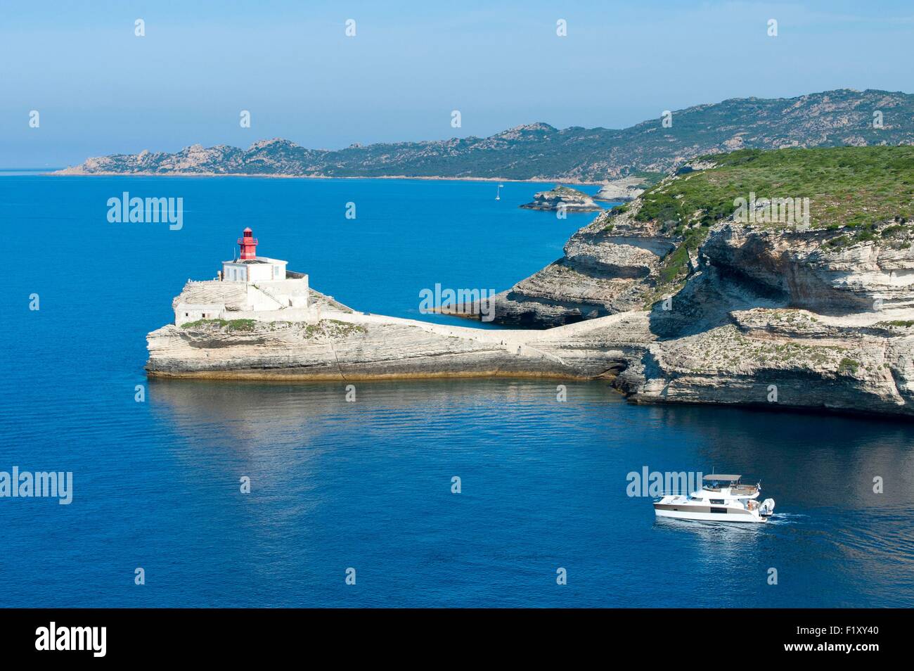 France, Corse du Sud, Bonifacio, Madonetta lighthouse, boat outgoing at sea Stock Photo