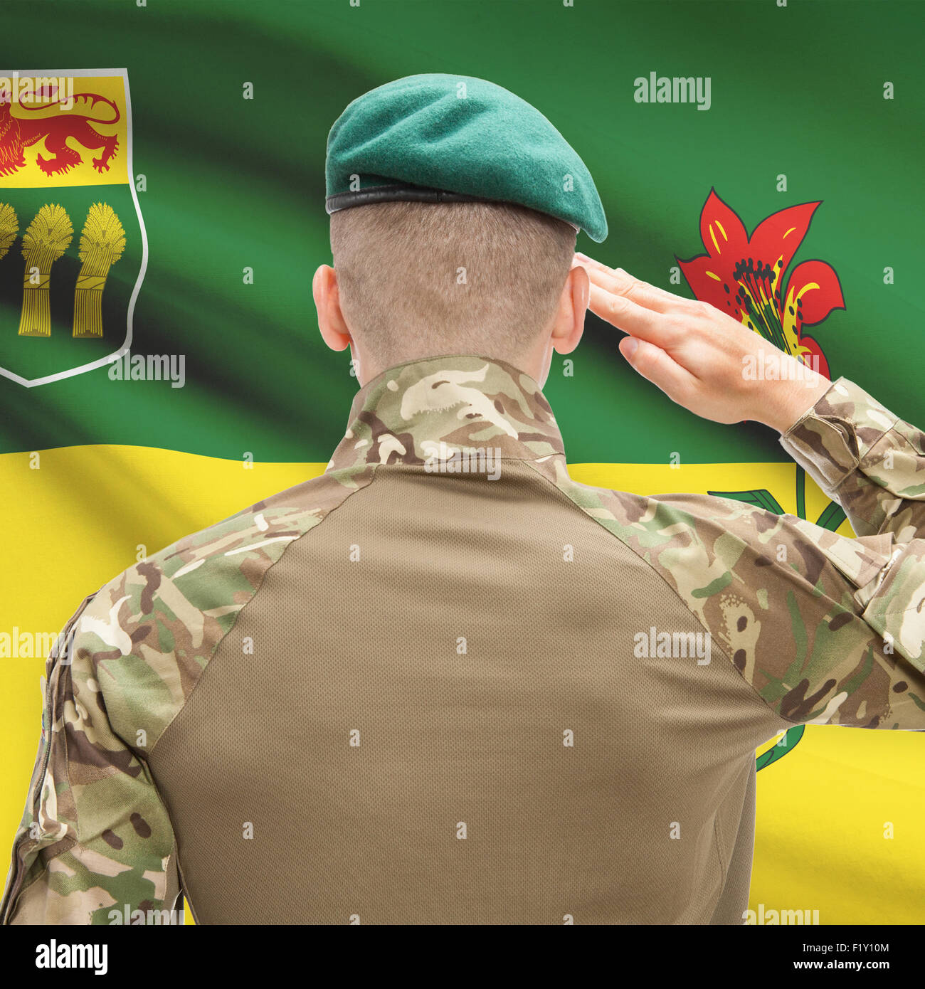 Soldier saluting to Canadial province flag series - Saskatchewan Stock Photo