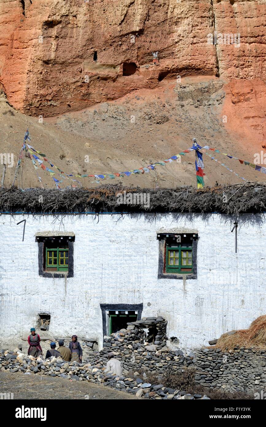 Nepal, Gandaki zone, Upper Mustang (near the border with Tibet), house in the village of Dhakmar and red cliff with caves Stock Photo
