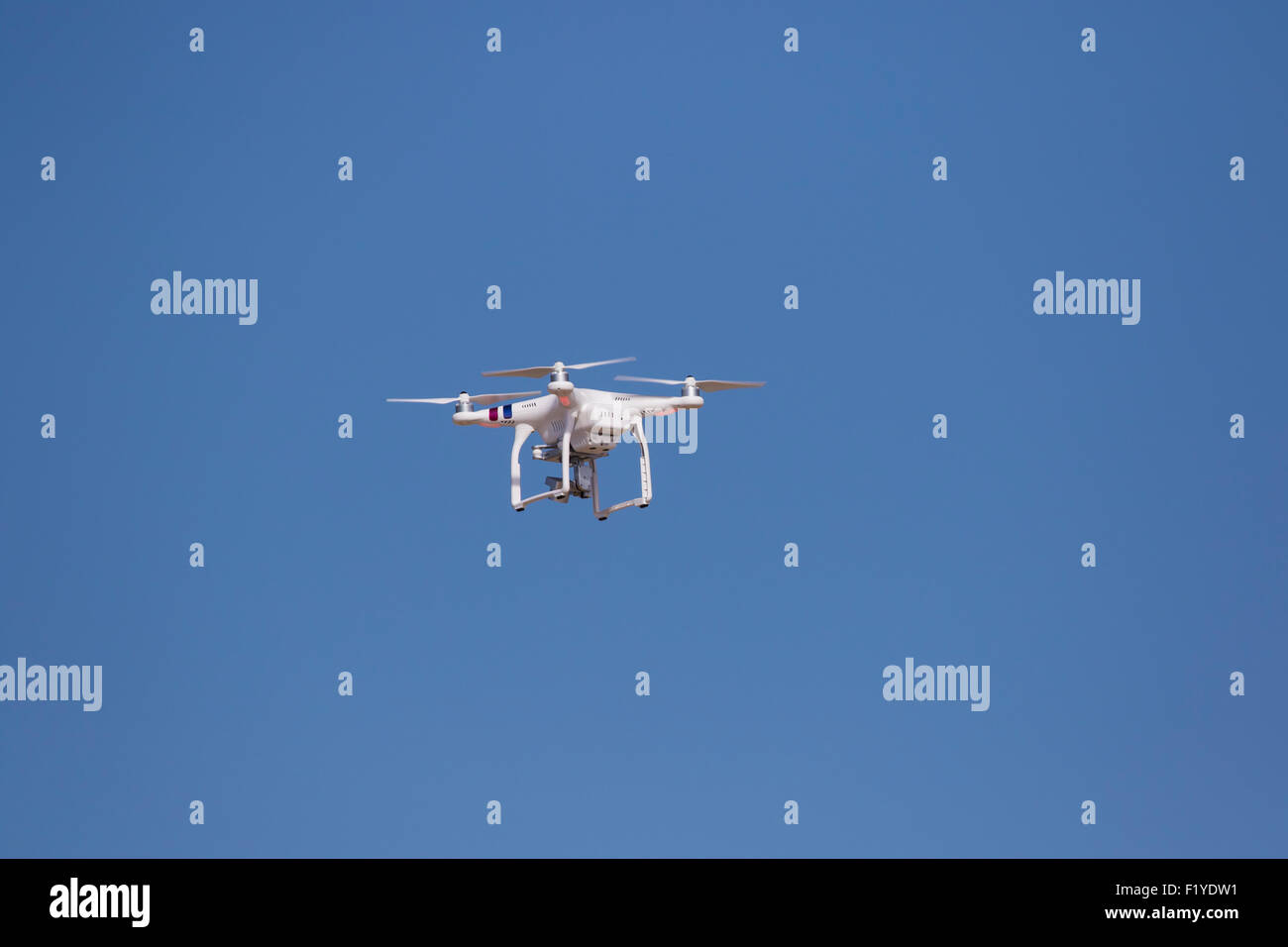 Drone flying against a vivid blue sky Stock Photo