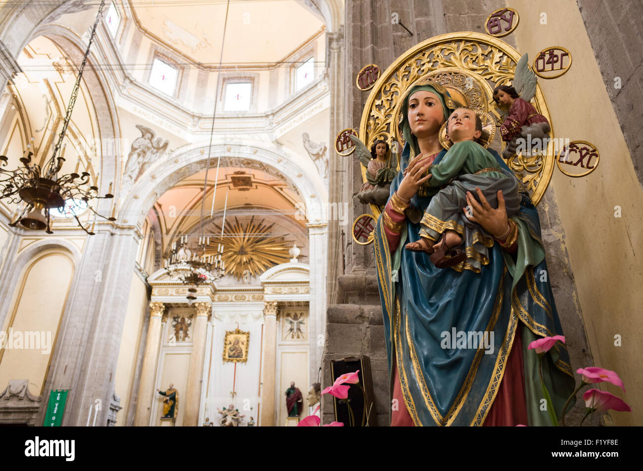 Mary And Child Statue Iglesia De La Santísima Trinidad Mexico City // MEXICO CITY, Mexico — A statue of Mary and Child stands before the main altar of Iglesia de la Santísima Trinidad (Church of the Holy Trinity). The church serves as one of Mexico City's Catholic parishes in the capital's extensive network of religious institutions. Iglesia de la Santísima Trinidad reflects the deep Catholic heritage that has shaped Mexican culture since the Spanish colonial period. The church continues to serve the local community as both a place of worship and spiritual gathering. Mexico City, founded on th Stock Photo