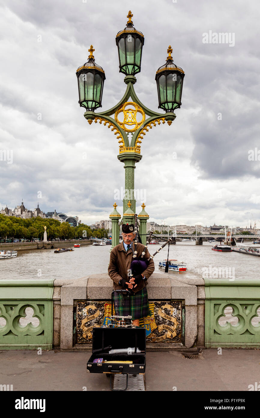 A Man Plays The Bagpipes On Westminster Bridge, London, England Stock Photo
