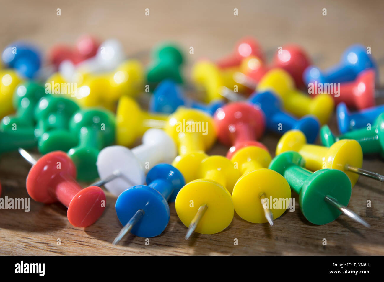 colored pushpins for noticeboard organized on a table Stock Photo